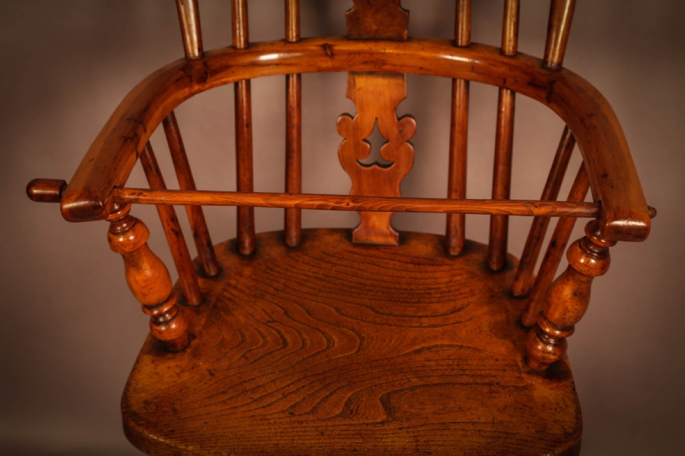 A yew wood Windsor childs high chair with a pierced splat back, turned legs, footrest, and safety bar. View IX
