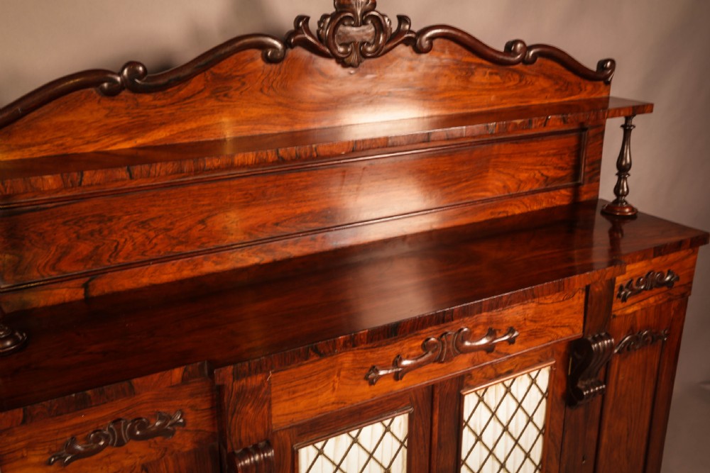 A Victorian rosewood four-door chiffonier featuring central wire latticework panels and a raised carved cresting rail on the backboard. View IX