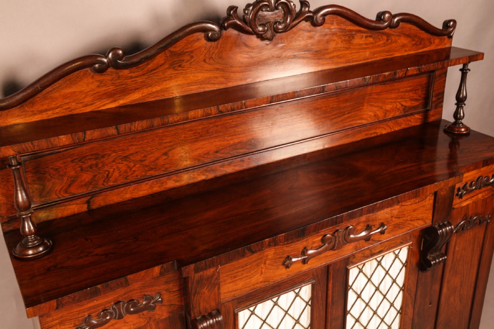 A Victorian rosewood four-door chiffonier featuring central wire latticework panels and a raised carved cresting rail on the backboard. View X