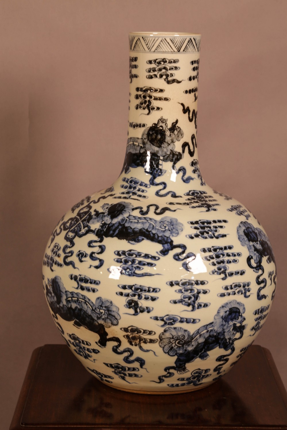 A large cylindrical and globular porcelain vase featuring hand-painted blue foo dogs and cloud motifs against a white glaze. View II