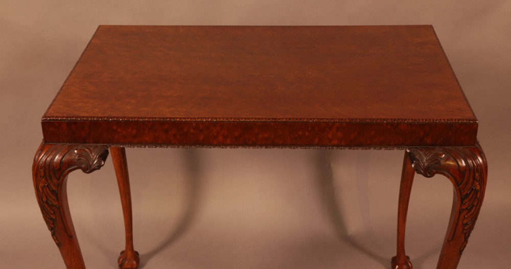 A Chippendale style wooden silver table featuring cabriole legs with carved knees, ball and claw feet, and a rectangular burr-veneered top. View III