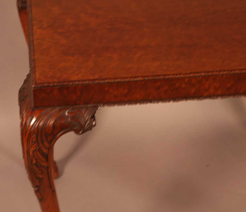 A Chippendale style wooden silver table featuring cabriole legs with carved knees, ball and claw feet, and a rectangular burr-veneered top. View VII