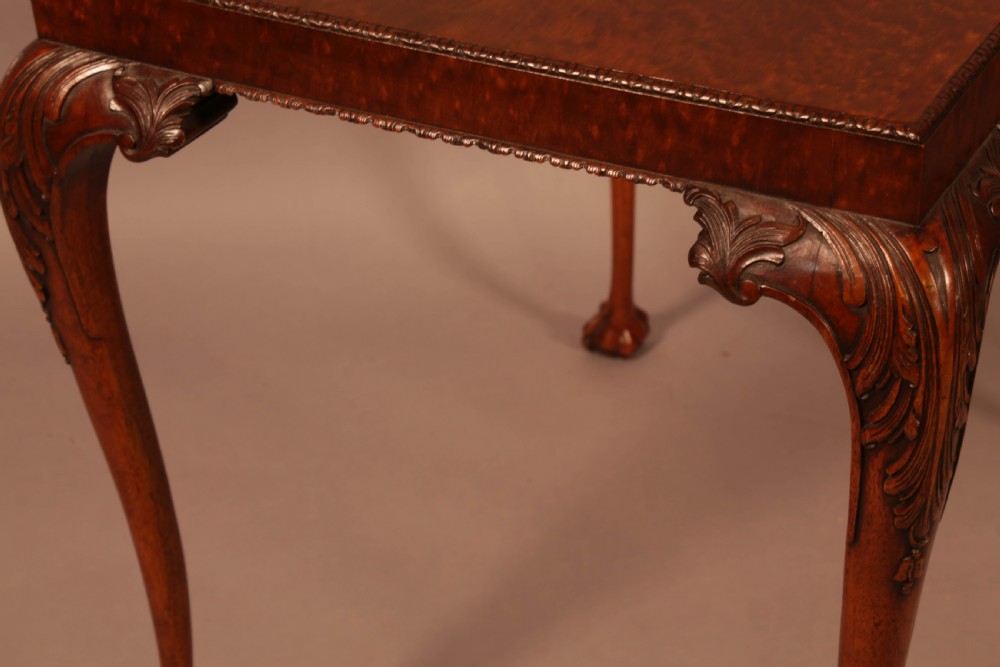 A Chippendale style wooden silver table featuring cabriole legs with carved knees, ball and claw feet, and a rectangular burr-veneered top. View VIII