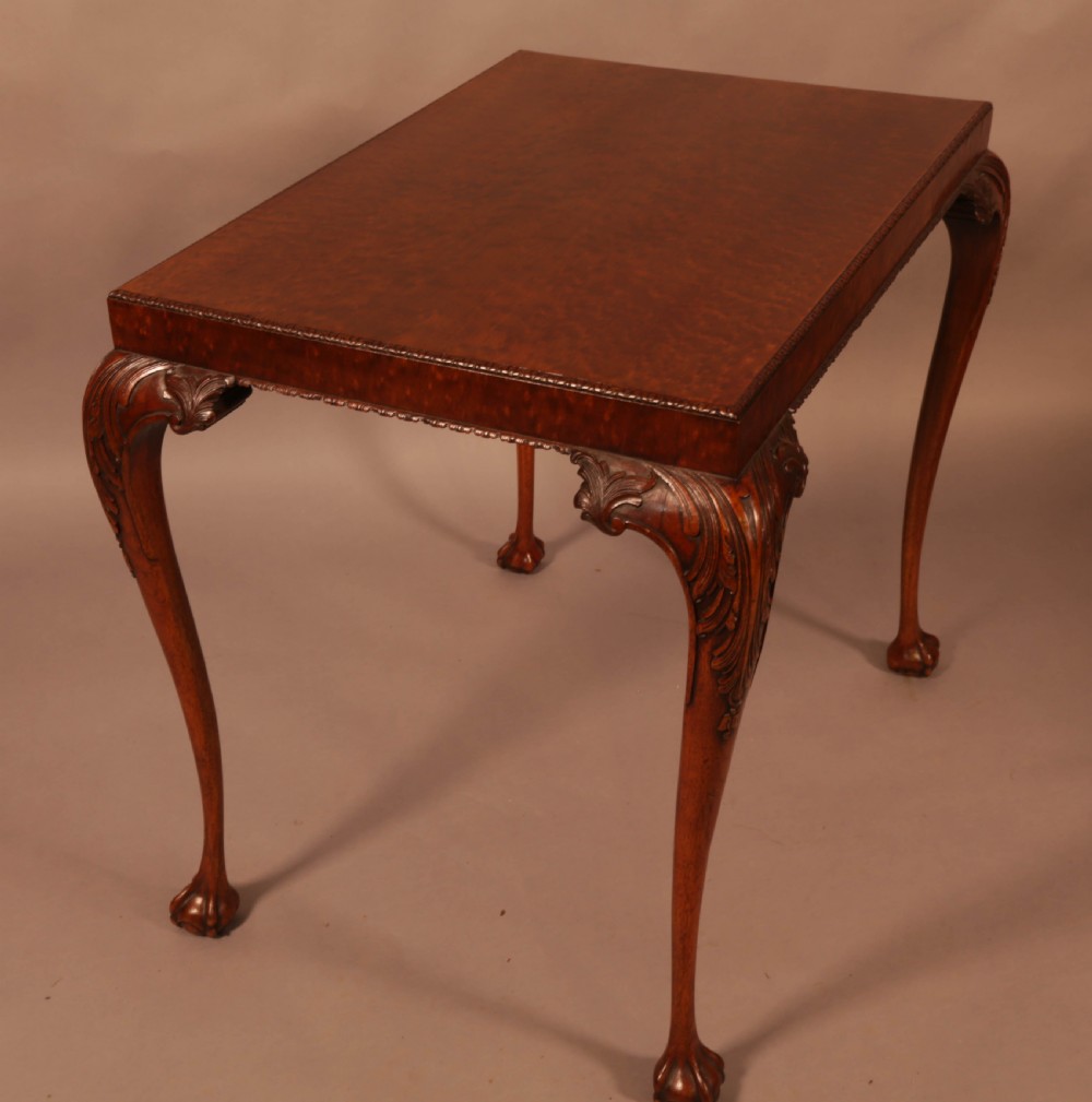 A Chippendale style wooden silver table featuring cabriole legs with carved knees, ball and claw feet, and a rectangular burr-veneered top. View IX