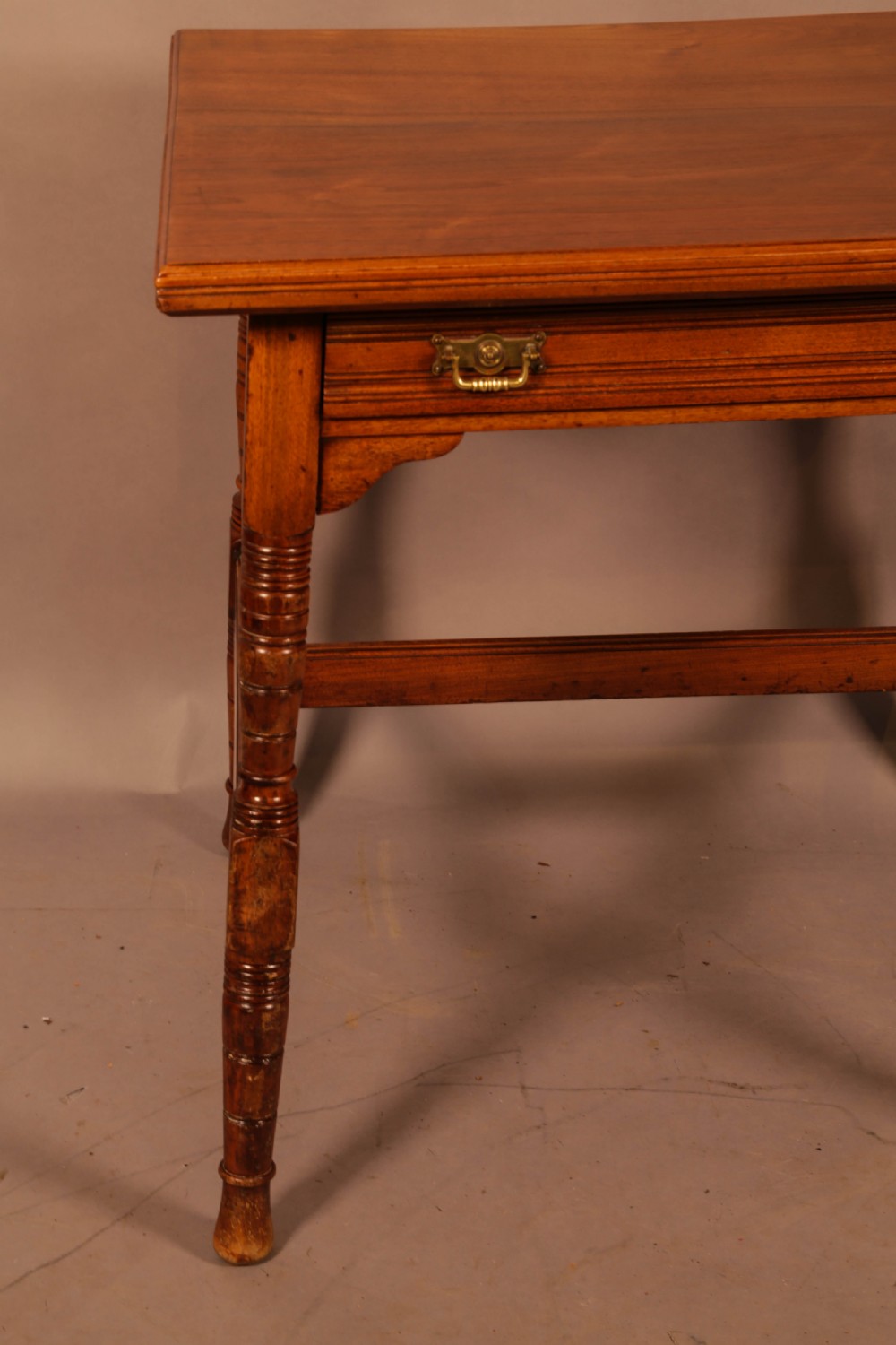 An Aesthetic Movement warm brown walnut occasional table with turned legs, a single drawer featuring brass handles, and a lower H-stretcher. View III