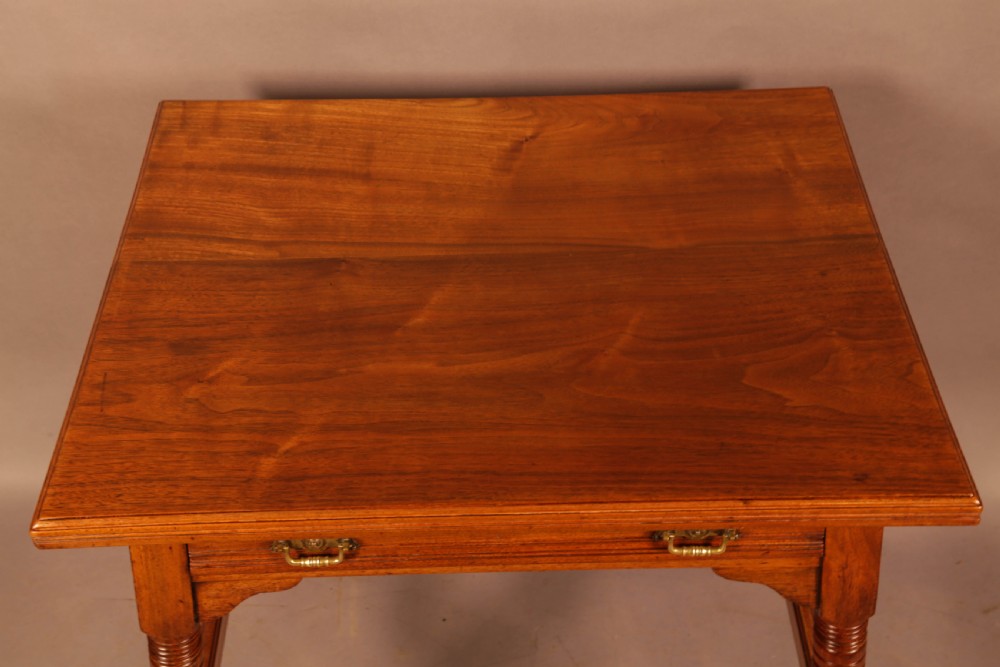 An Aesthetic Movement warm brown walnut occasional table with turned legs, a single drawer featuring brass handles, and a lower H-stretcher. View IV