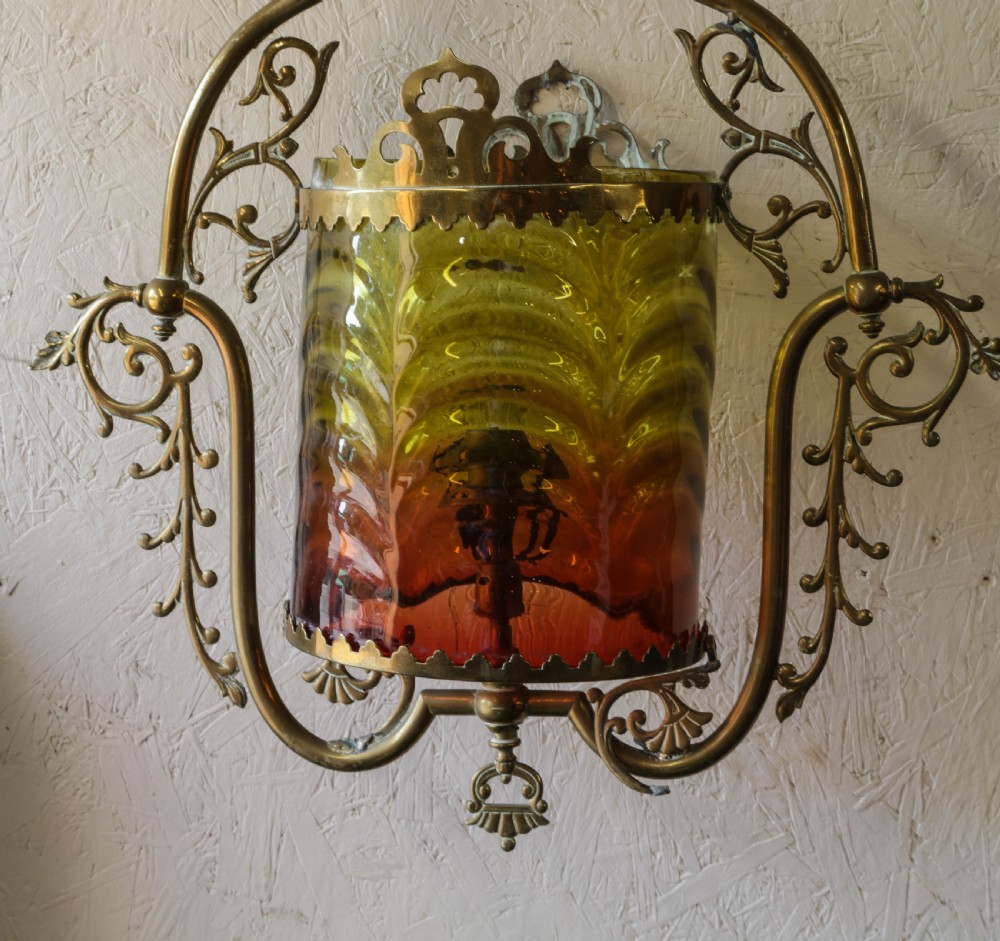 Victorian brass hanging lantern featuring an ornate scrollwork frame enclosing a cylindrical shade with graded yellow and red glass. View III