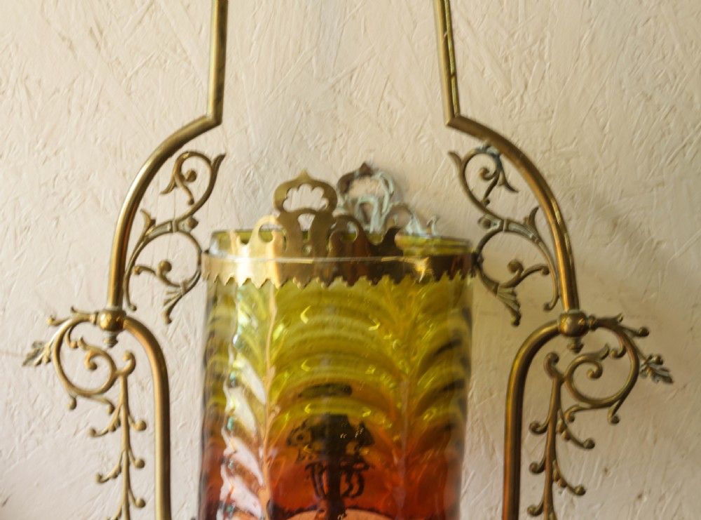 Victorian brass hanging lantern featuring an ornate scrollwork frame enclosing a cylindrical shade with graded yellow and red glass. View V