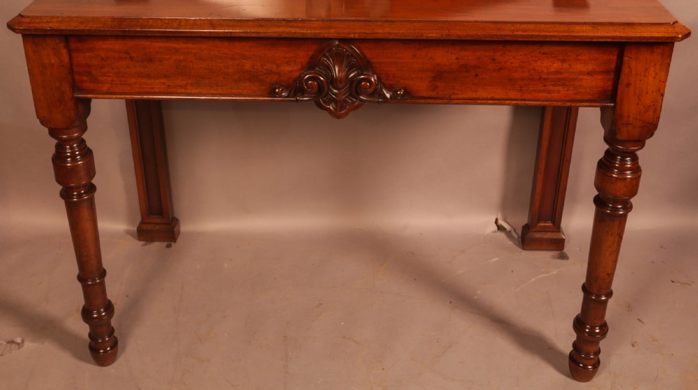 A Victorian mahogany serving table featuring a carved decorative backboard and turned front legs. View III
