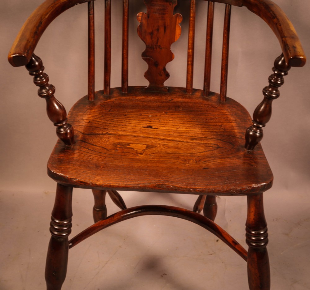 An antique 19th-century yew wood Windsor armchair featuring a hoop back, pierced central splat, turned legs, and a bow stretcher. View IV