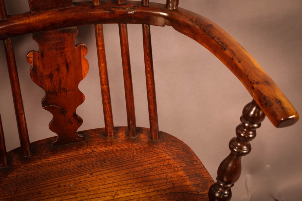 An antique 19th-century yew wood Windsor armchair featuring a hoop back, pierced central splat, turned legs, and a bow stretcher. View VIII