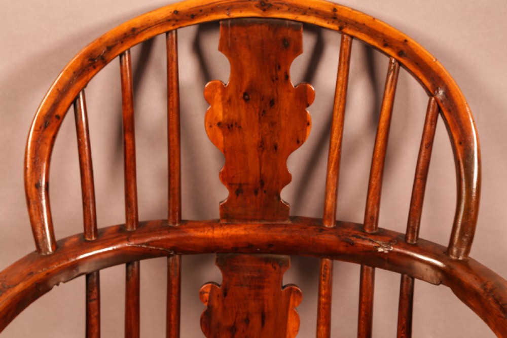 An antique 19th-century yew wood Windsor armchair featuring a hoop back, pierced central splat, turned legs, and a bow stretcher. View IX