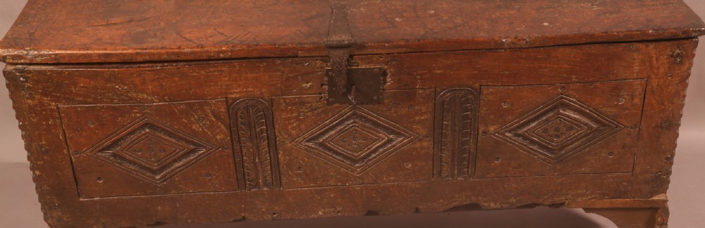 A dark oak early seventeenth-century five-plank coffer featuring carved lozenge panel decoration and hand-forged iron hardware. View III