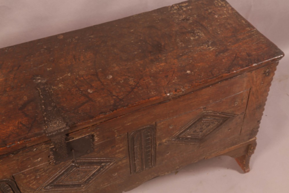 A dark oak early seventeenth-century five-plank coffer featuring carved lozenge panel decoration and hand-forged iron hardware. View VI