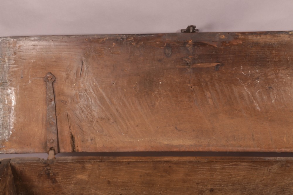 A dark oak early seventeenth-century five-plank coffer featuring carved lozenge panel decoration and hand-forged iron hardware. View VIII