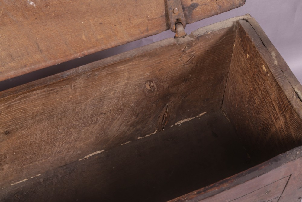 A dark oak early seventeenth-century five-plank coffer featuring carved lozenge panel decoration and hand-forged iron hardware. View IX