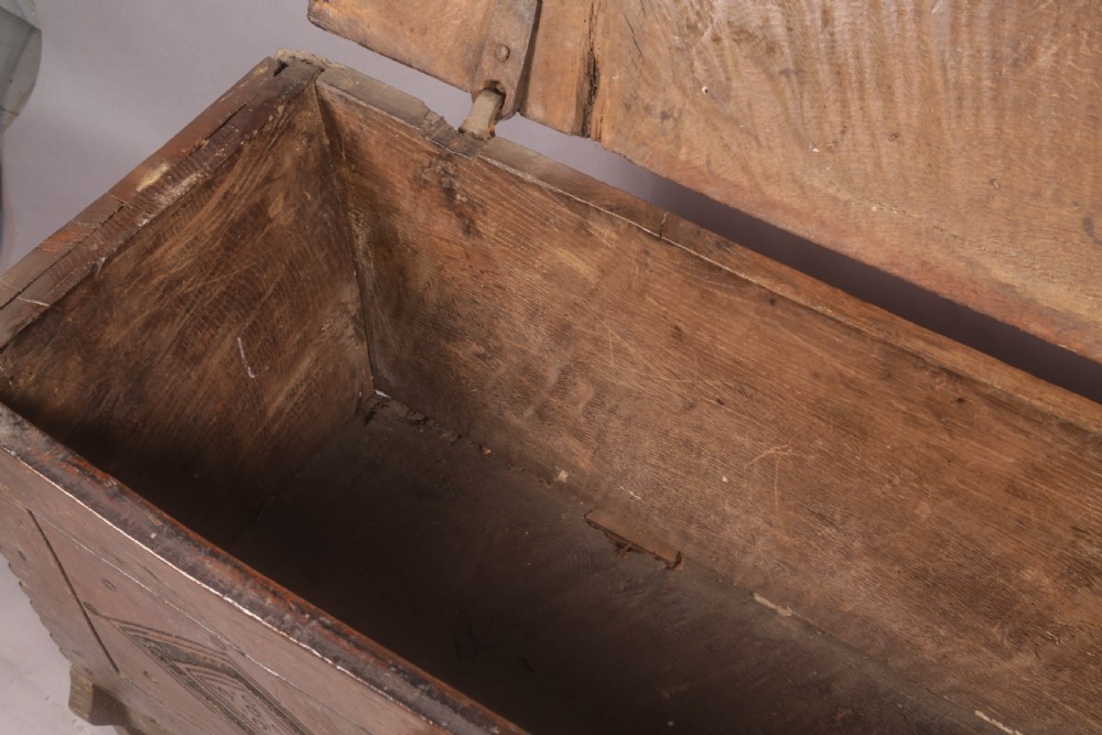 A dark oak early seventeenth-century five-plank coffer featuring carved lozenge panel decoration and hand-forged iron hardware. View X