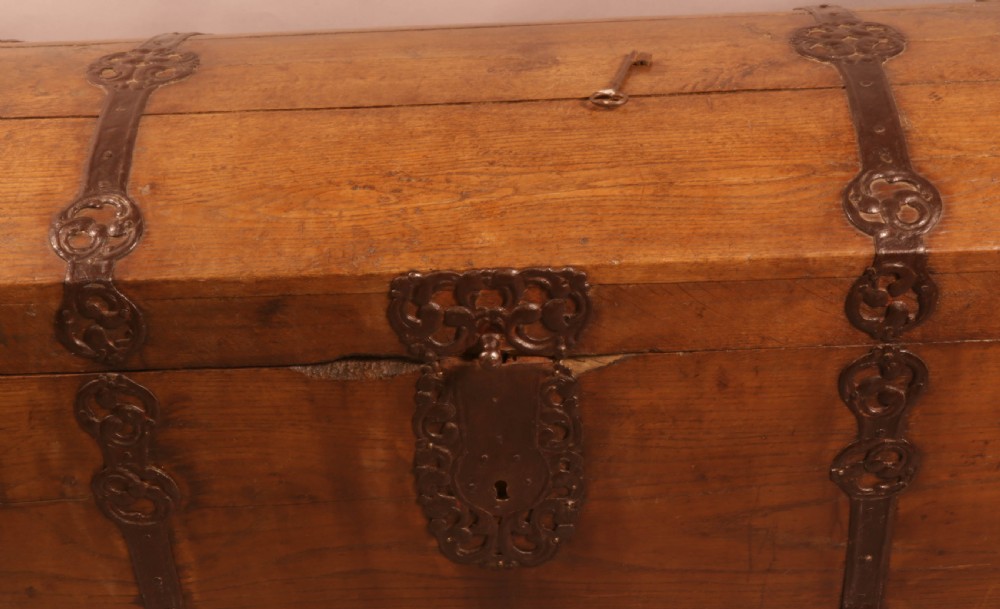An 18th-century oak trunk with a domed lid and decorative iron strapwork. View II