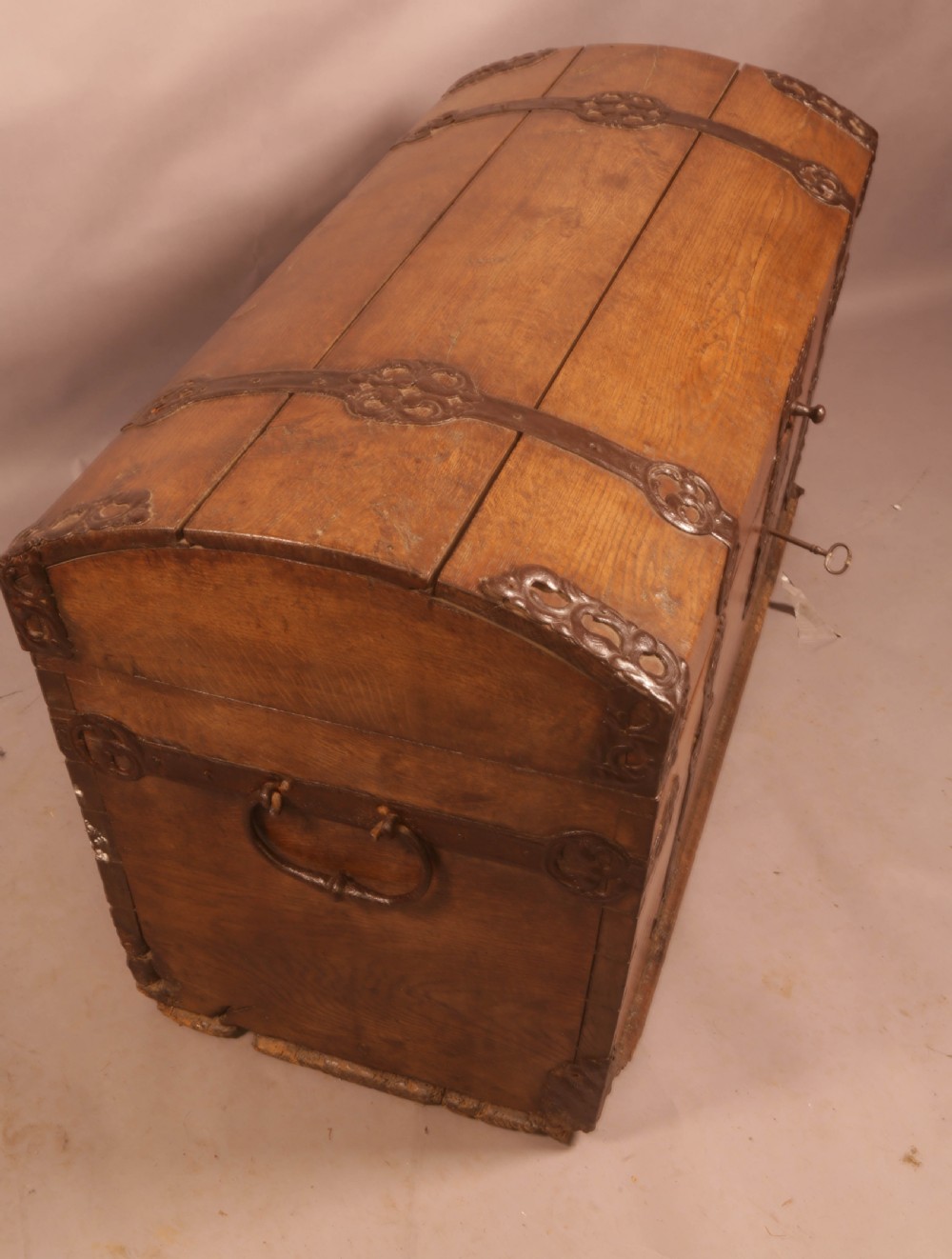 An 18th-century oak trunk with a domed lid and decorative iron strapwork. View VII
