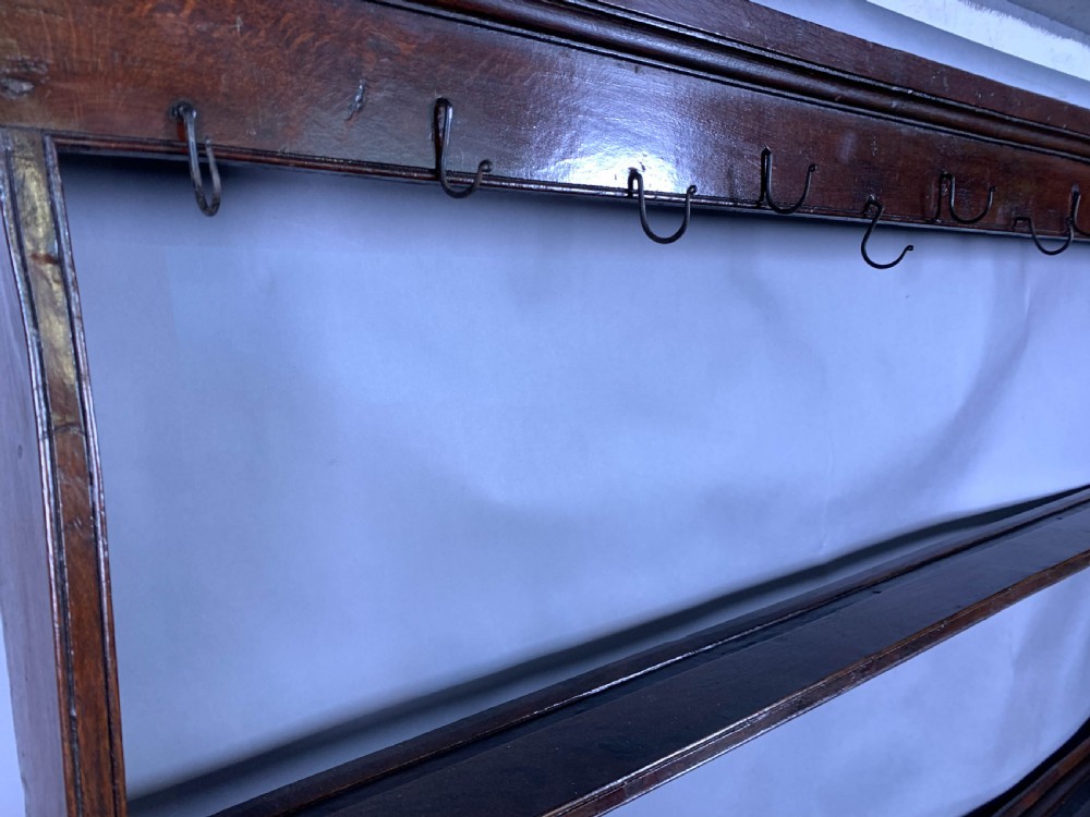 An 18th-century oak Welsh dresser featuring an open rack top with plate hooks, a central base with multiple drawers, and a lower pot board shelf. View VIII