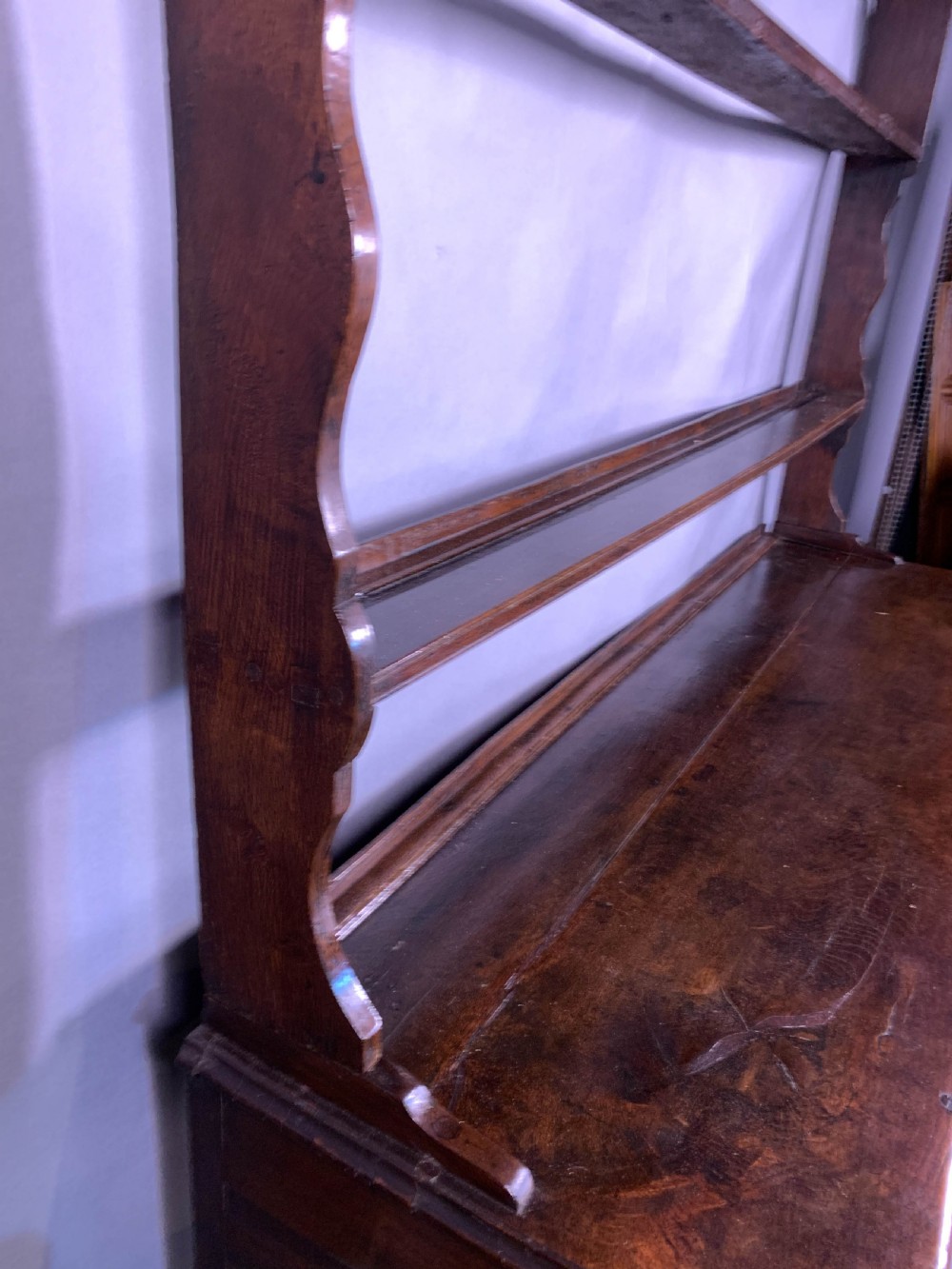 An 18th-century oak Welsh dresser featuring an open rack top with plate hooks, a central base with multiple drawers, and a lower pot board shelf. View XI