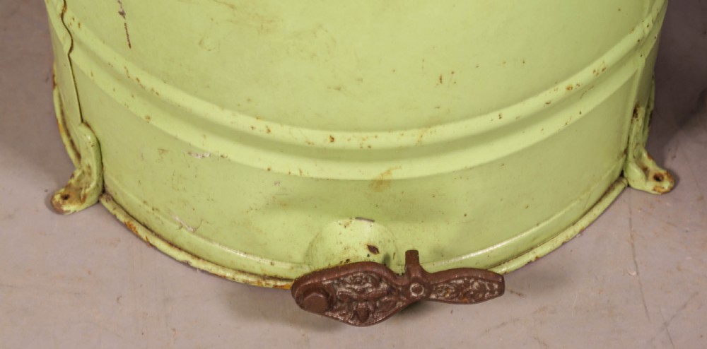 A pale green cylindrical metal honey separator with a top-mounted cast iron hand-crank mechanism and wooden handle. View VI