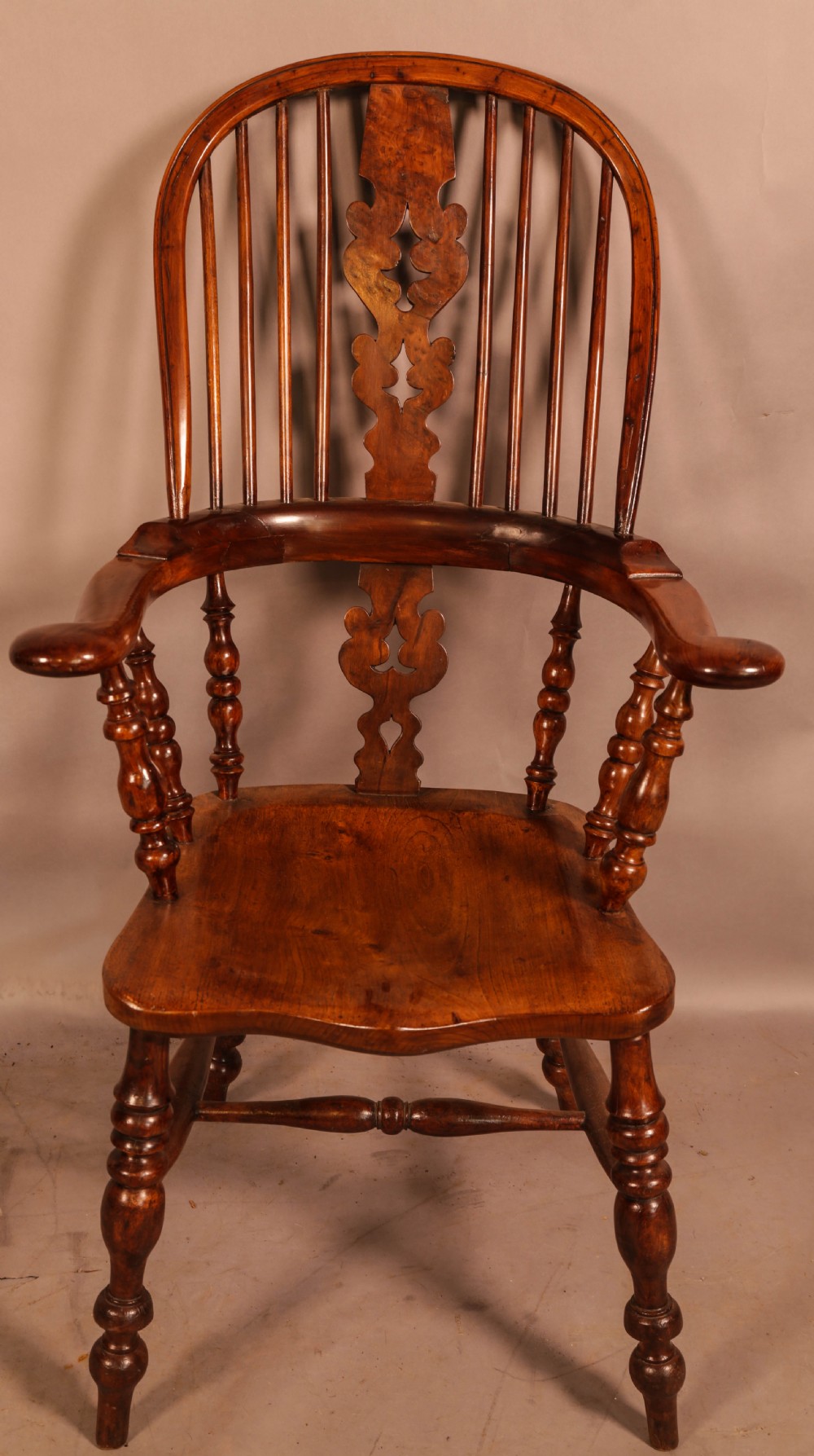 An antique yew wood Windsor armchair featuring a bowed hoop back, pierced splat, turned legs, and a solid elm seat. View II