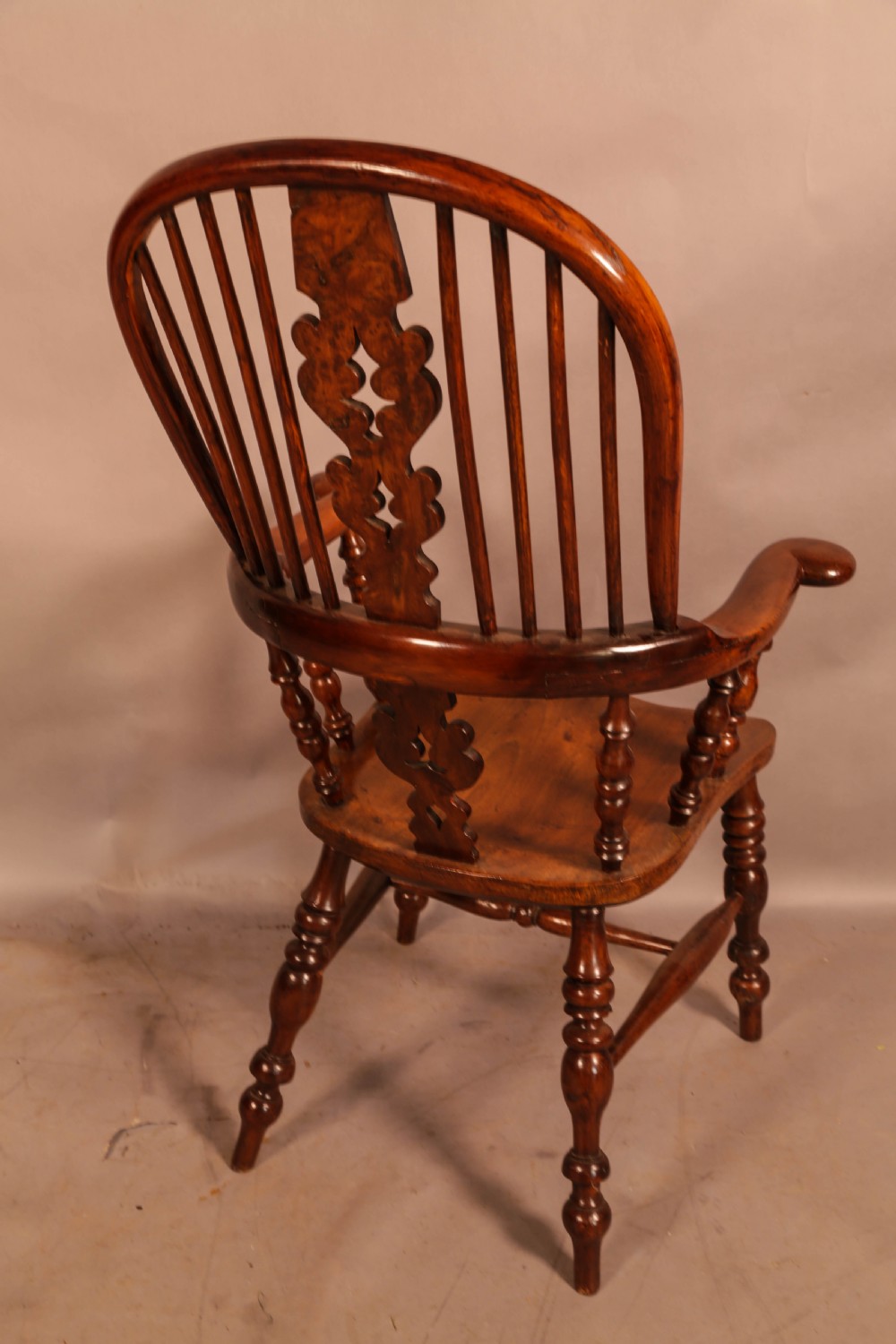 An antique yew wood Windsor armchair featuring a bowed hoop back, pierced splat, turned legs, and a solid elm seat. View III