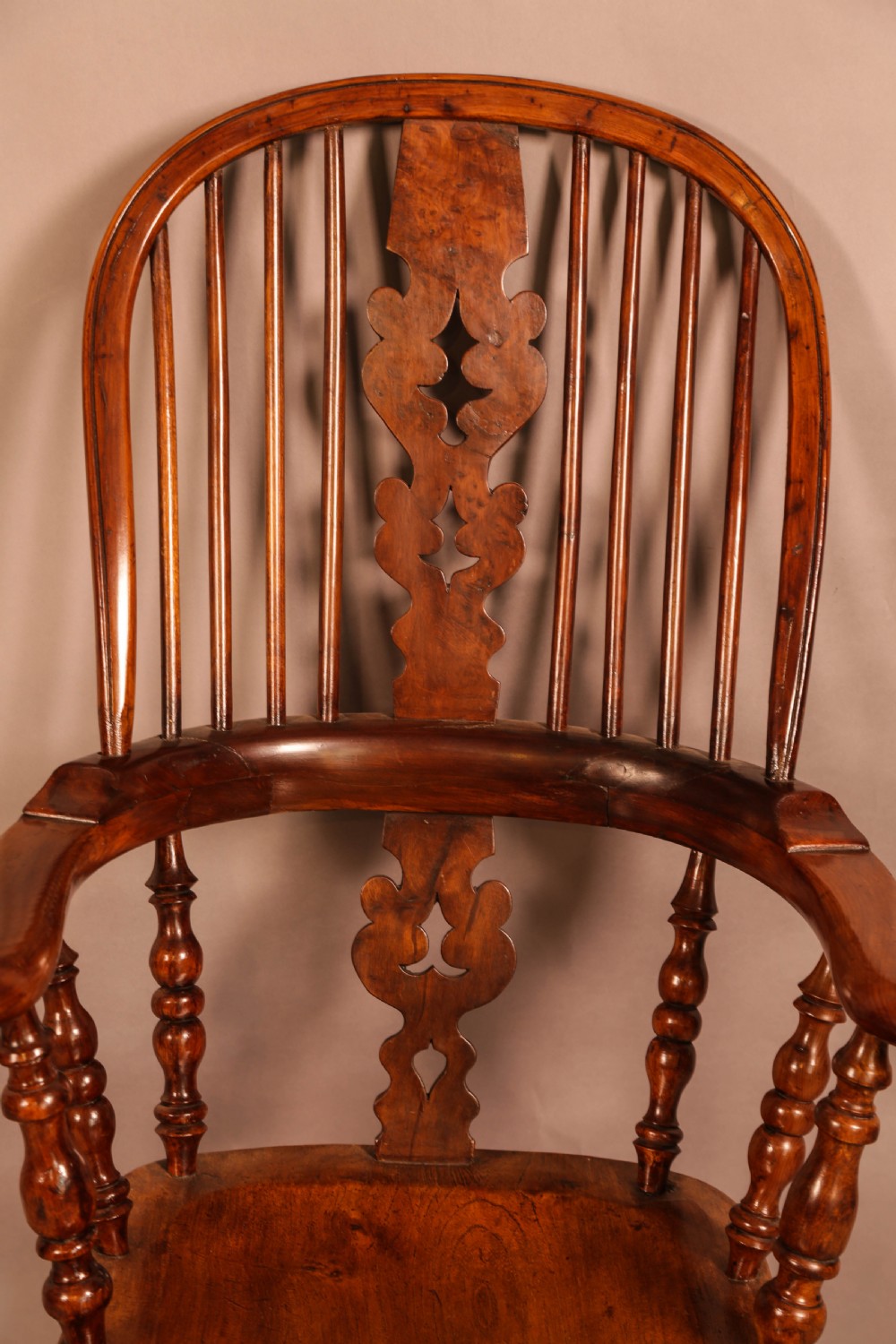 An antique yew wood Windsor armchair featuring a bowed hoop back, pierced splat, turned legs, and a solid elm seat. View VII