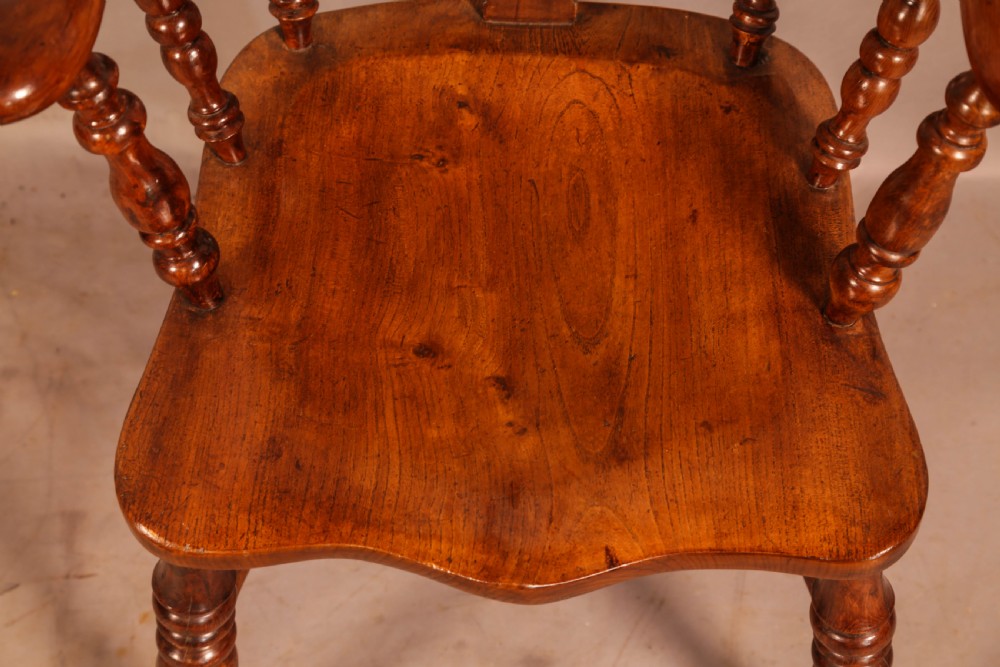 An antique yew wood Windsor armchair featuring a bowed hoop back, pierced splat, turned legs, and a solid elm seat. View IX