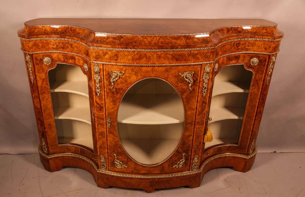 A serpentine-front Victorian burr walnut credenza featuring glazed doors, gilt bronze ormolu mounts, and intricate wood figuring. View II