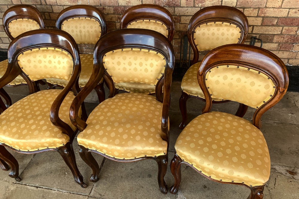 A set of eight Victorian mahogany dining chairs featuring gold patterned fabric upholstery, balloon backs, and cabriole legs. View II