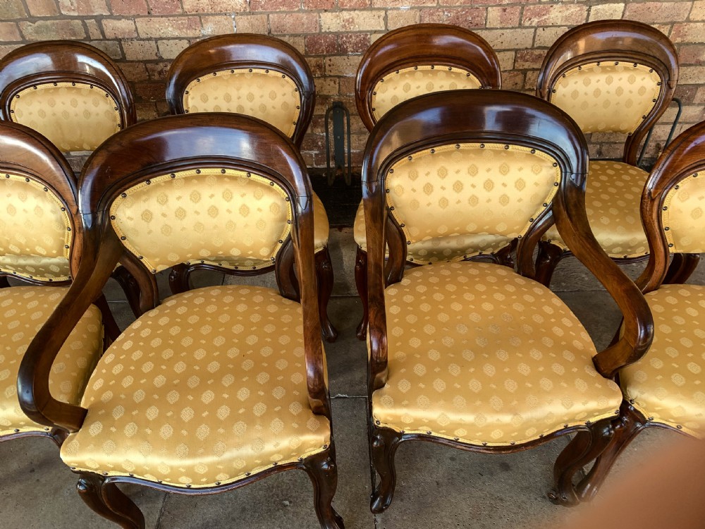 A set of eight Victorian mahogany dining chairs featuring gold patterned fabric upholstery, balloon backs, and cabriole legs. View XIV