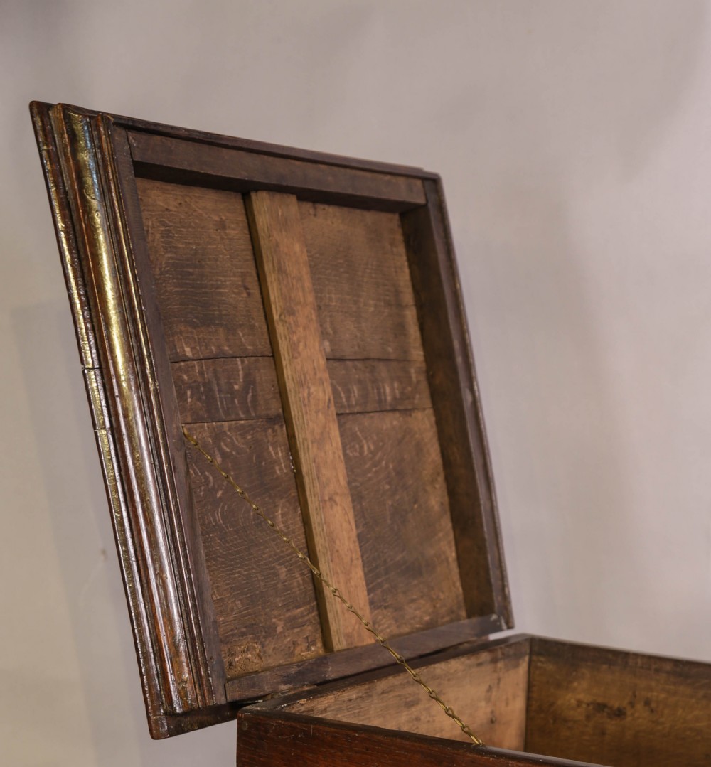 An 18th-century oak close stool designed with four faux drawer fronts, brass drop handles, and bracket feet. View V