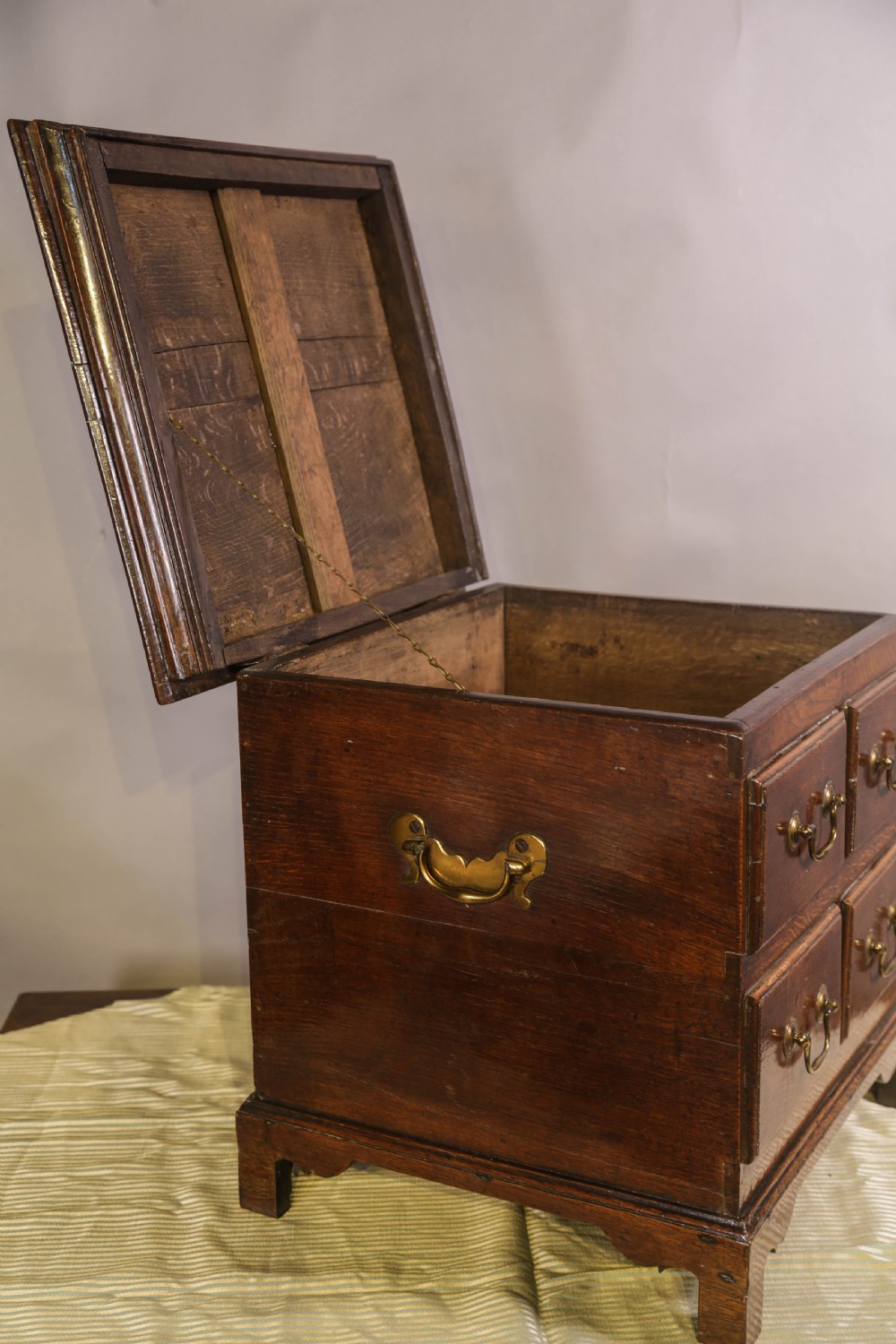 An 18th-century oak close stool designed with four faux drawer fronts, brass drop handles, and bracket feet. View VIII