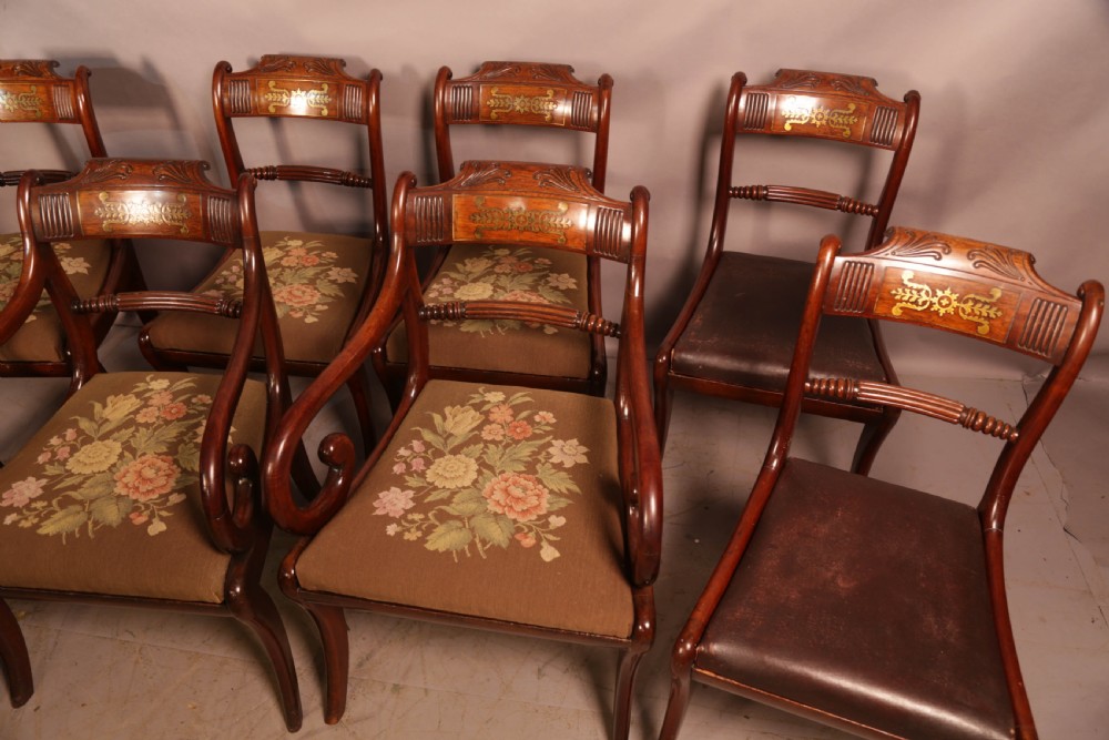 A matched set of eight Regency mahogany dining chairs featuring brass inlay on the top rails and upholstered seats. View III