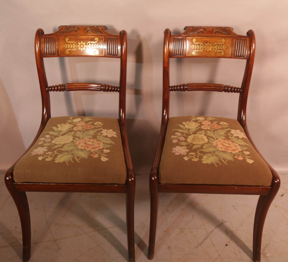 A matched set of eight Regency mahogany dining chairs featuring brass inlay on the top rails and upholstered seats. View VII