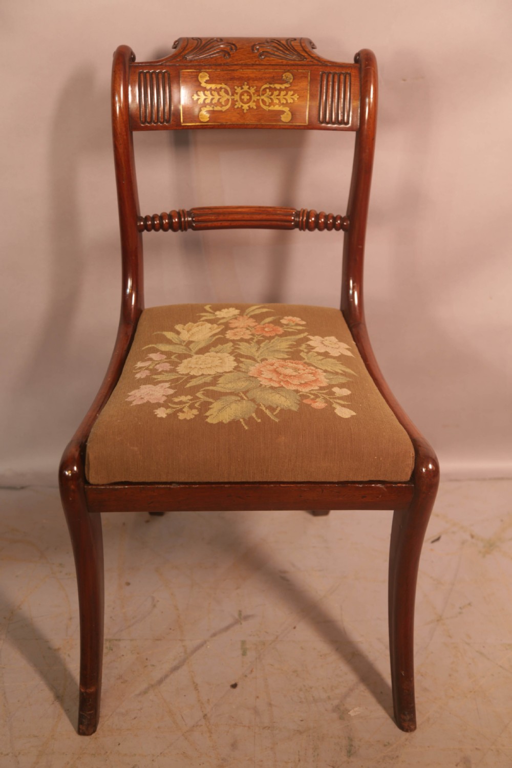 A matched set of eight Regency mahogany dining chairs featuring brass inlay on the top rails and upholstered seats. View VIII