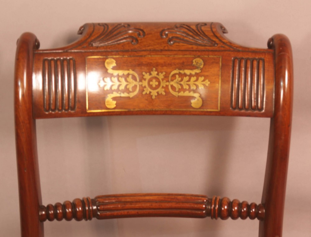 A matched set of eight Regency mahogany dining chairs featuring brass inlay on the top rails and upholstered seats. View XIII