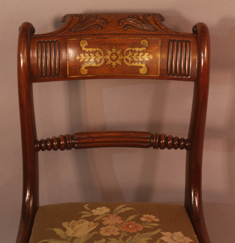 A matched set of eight Regency mahogany dining chairs featuring brass inlay on the top rails and upholstered seats. View XV