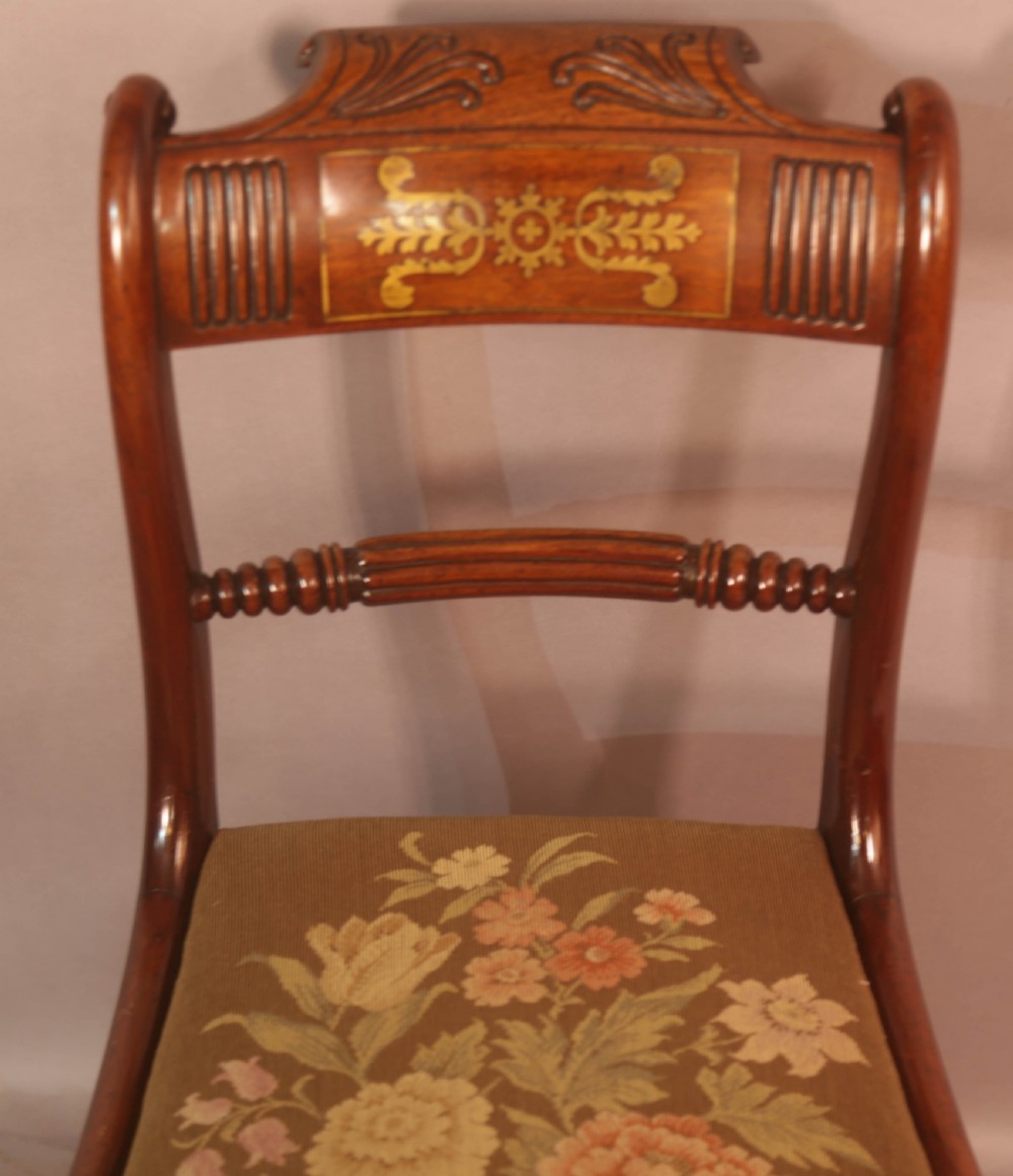 A matched set of eight Regency mahogany dining chairs featuring brass inlay on the top rails and upholstered seats. View XVIII