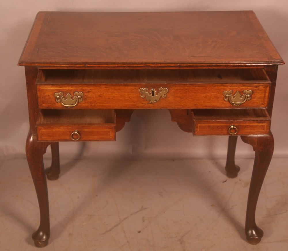An eighteenth-century oak side table featuring a rectangular top, cabriole legs, and three drawers with brass drop handles. View III