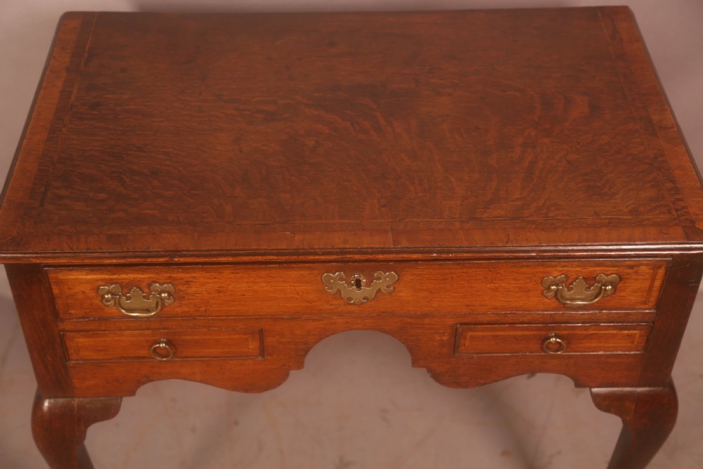 An eighteenth-century oak side table featuring a rectangular top, cabriole legs, and three drawers with brass drop handles. View IV