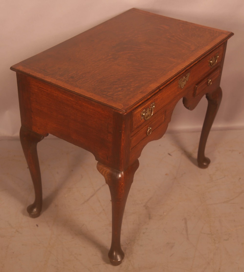 An eighteenth-century oak side table featuring a rectangular top, cabriole legs, and three drawers with brass drop handles. View VIII