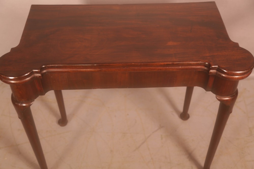A mid-18th century Georgian mahogany fold-over card table featuring projecting rounded corners, a smooth apron, and slender cabriole legs terminating in pad feet. View III