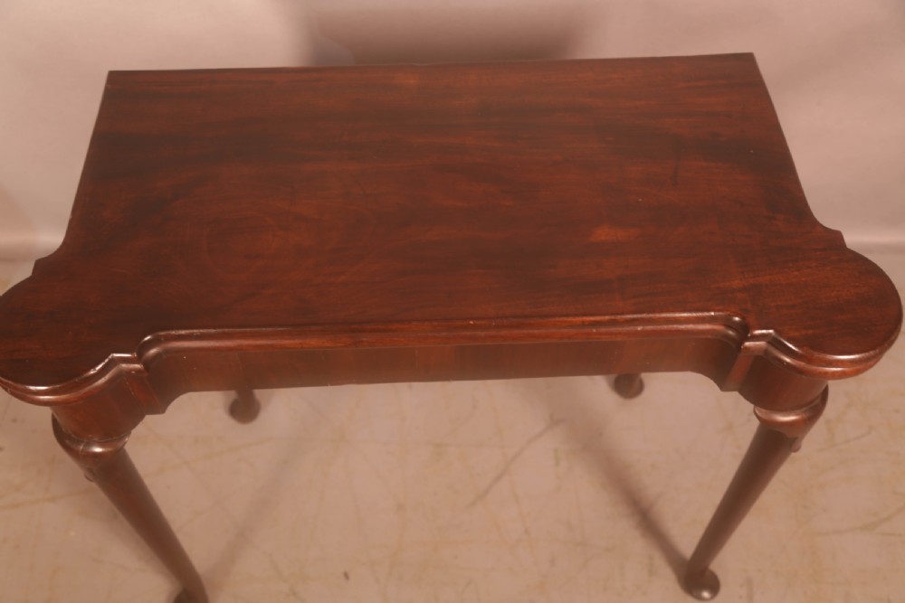 A mid-18th century Georgian mahogany fold-over card table featuring projecting rounded corners, a smooth apron, and slender cabriole legs terminating in pad feet. View II