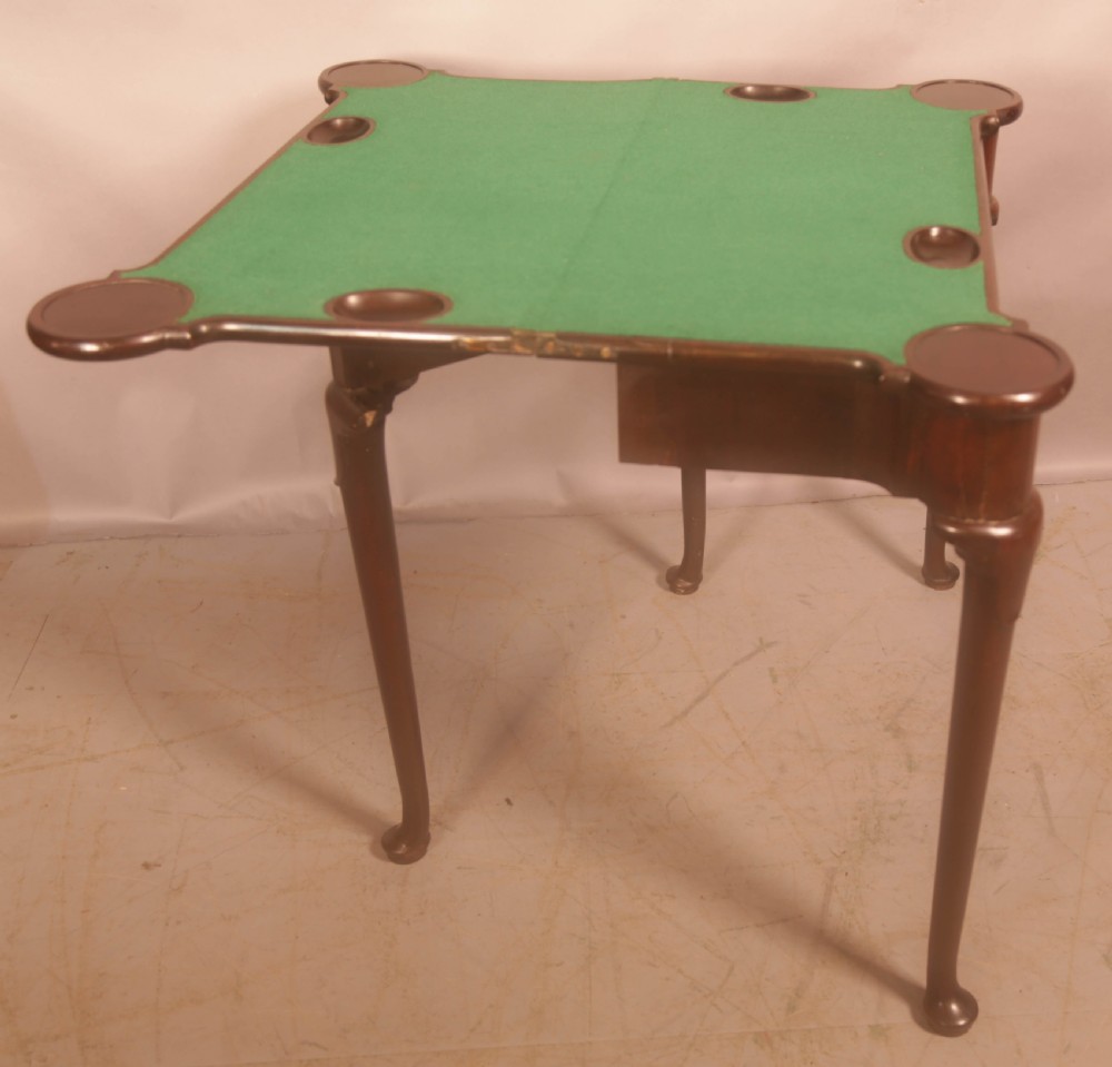 A mid-18th century Georgian mahogany fold-over card table featuring projecting rounded corners, a smooth apron, and slender cabriole legs terminating in pad feet. View VI