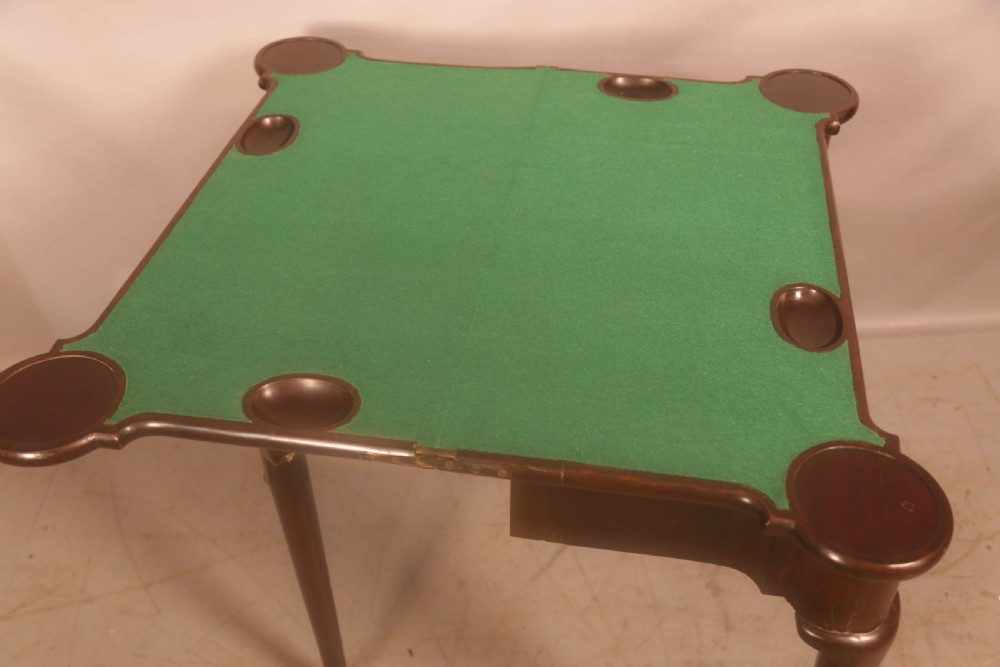 A mid-18th century Georgian mahogany fold-over card table featuring projecting rounded corners, a smooth apron, and slender cabriole legs terminating in pad feet. View VII