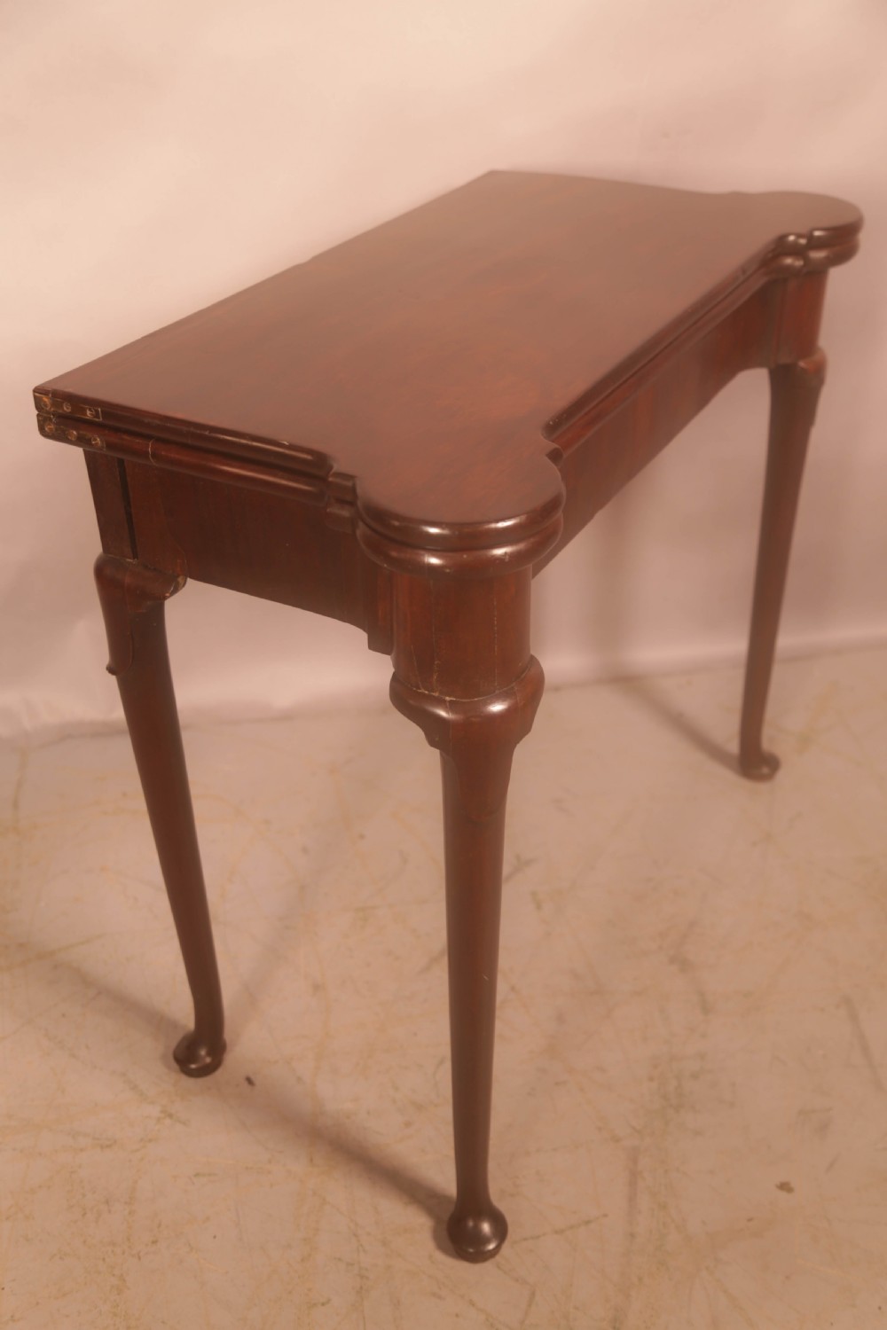 A mid-18th century Georgian mahogany fold-over card table featuring projecting rounded corners, a smooth apron, and slender cabriole legs terminating in pad feet. View VIII