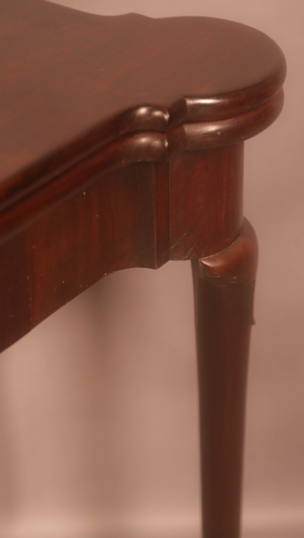 A mid-18th century Georgian mahogany fold-over card table featuring projecting rounded corners, a smooth apron, and slender cabriole legs terminating in pad feet. View X